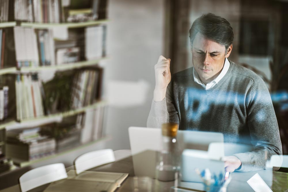 Man som sitter och tittar på en laptop